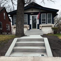 Newly installed concrete staircase the blend with the homes modern architecture and lead to a concrete pathway to the front door