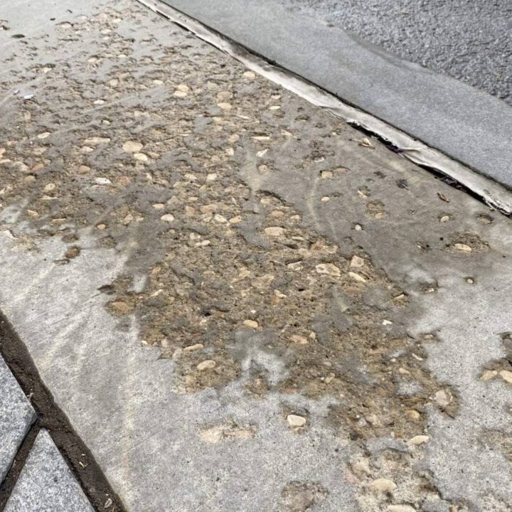 A driveway that is showing signs of wear from the weather that needs replaced or repaired