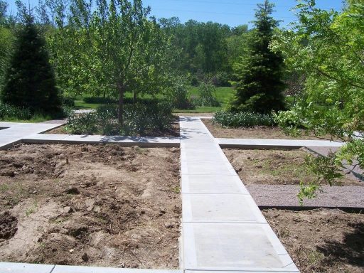 New concrete pathway that allows you to walk in multiple directions throughout a garden