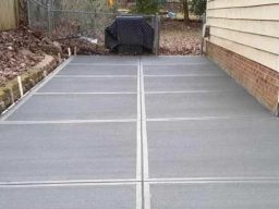 New interlocking paver patio with a square design on the side of a home