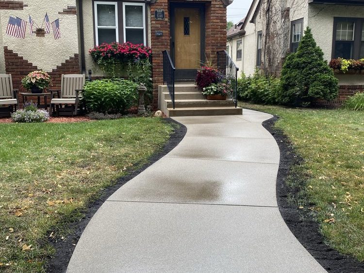 New curved concrete pathway to the front door of a home 