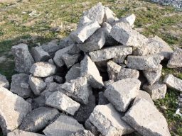 A pile of concrete chunks, ranging in size, with rough and irregular edges. The debris is scattered haphazardly, creating a mound of broken concrete pieces