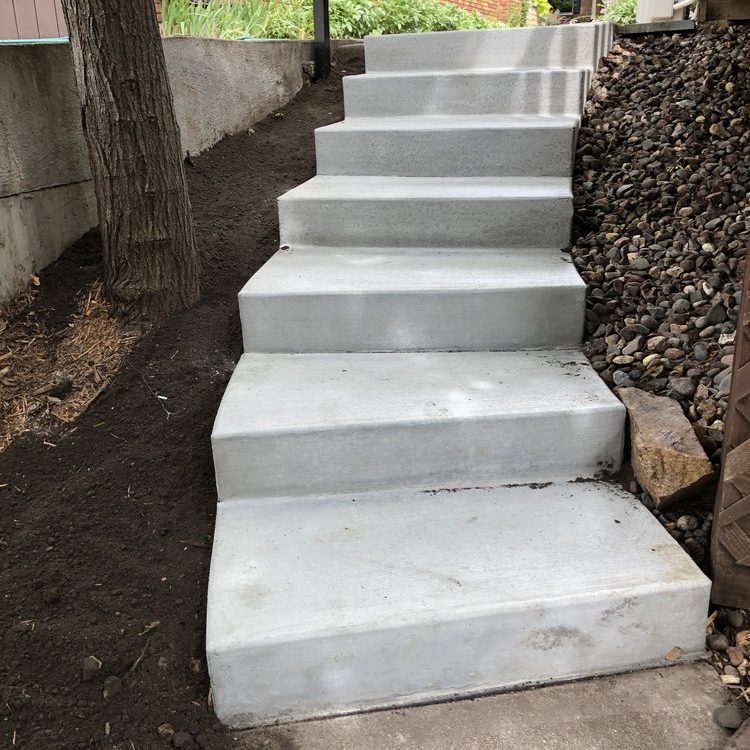 Newly installed concrete steps that curve down to a backyard